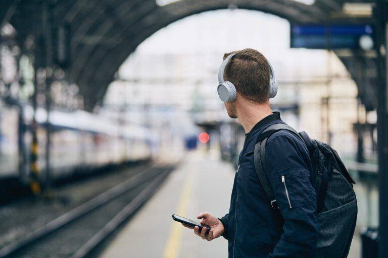 Man with headphones waiting for train